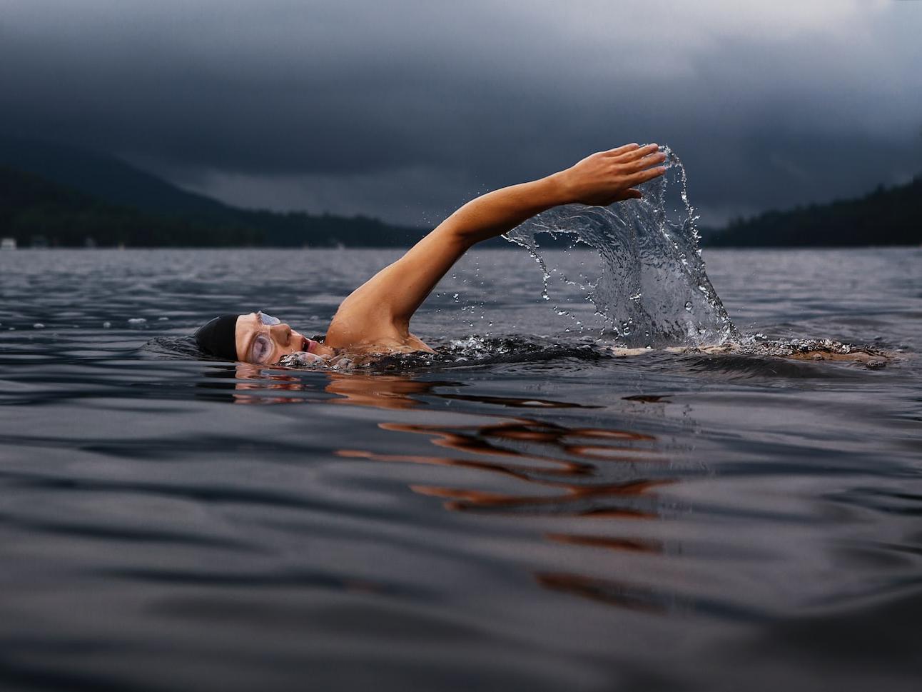 man swimming on body of water